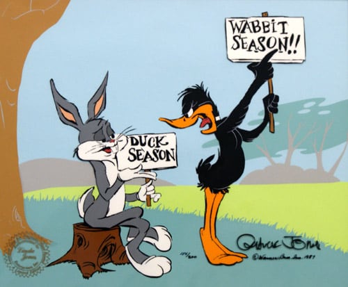 Bugs Bunny and Daffy duck holding "duck season" and "wabbit season" signs.