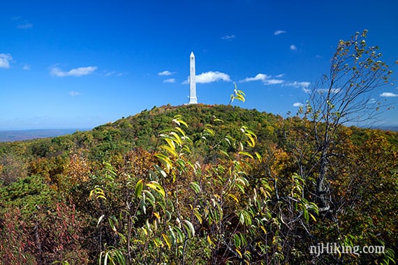 High Point State Park monument on a hill surrounded by early fall foliage.