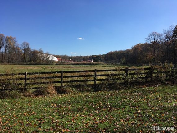 Low fence around grassy Watchung Stables.