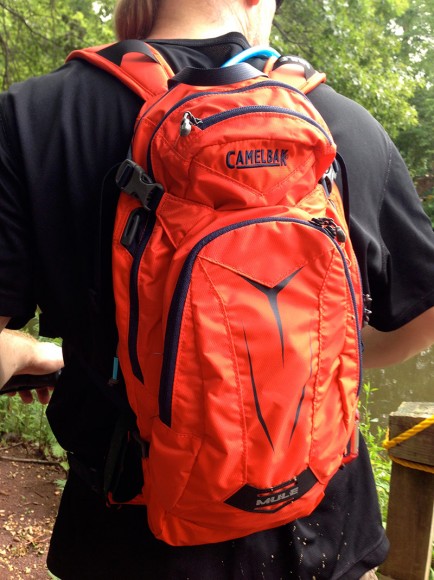 Bright orange Camelback M.U.L.E backpack on a hiker.