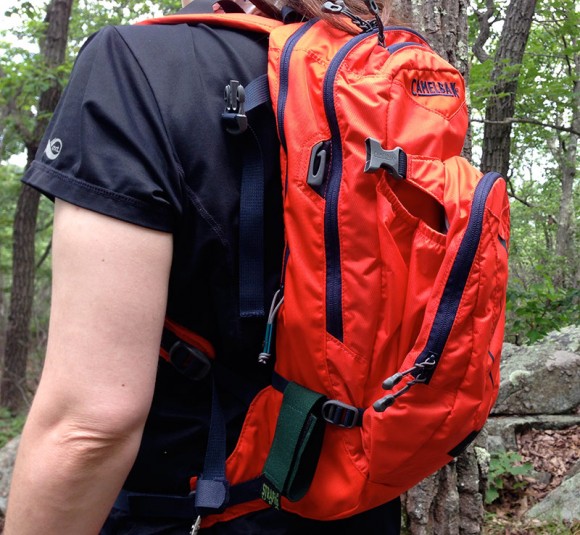 Hiker wearing an orange hydration backpack.