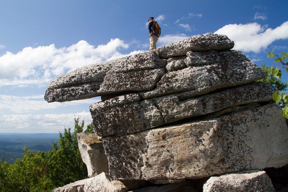 Hiker standing on Indian Rock at Sam's Point Preserve.