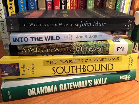 Stack of hiking books on a desk.