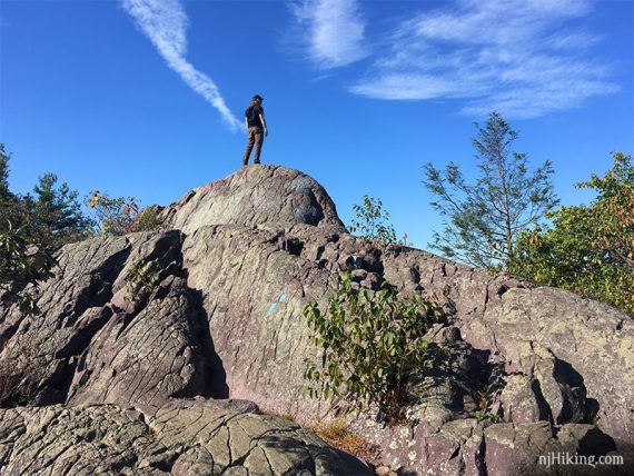 Hiker standing on a protruding fin of rock.