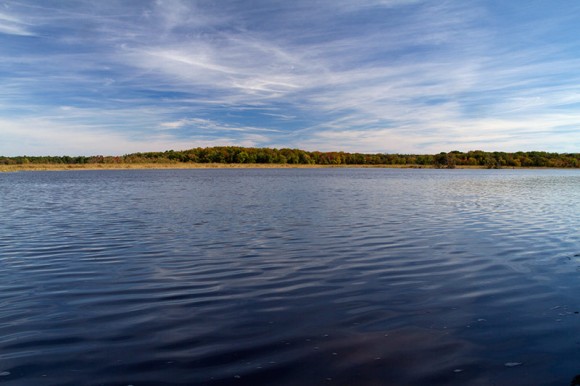 Maurice River with wispy clouds in a blue sky overhead.