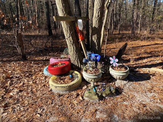 Planters and tires at the base of a tree as a memorial.