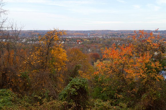 Bright organge foliage in the foreground with the town of New Hope in the distance.