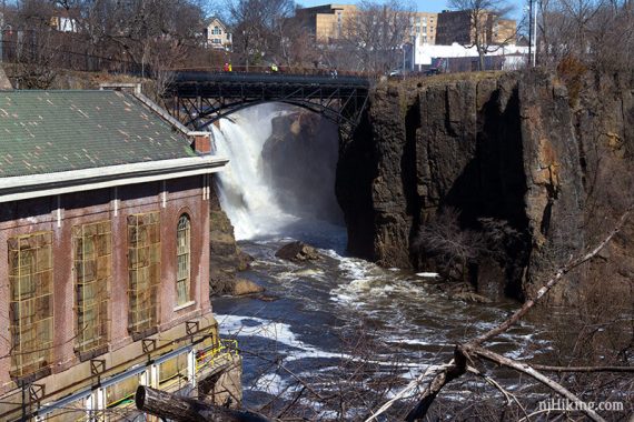 Waterfall seen under a large footbridge.