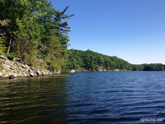 Rocky shoreline against a blue lake.