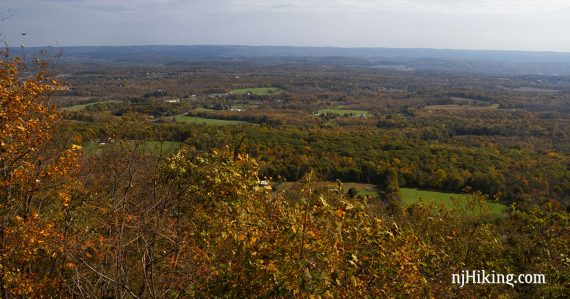View over a valley with forests and farms.
