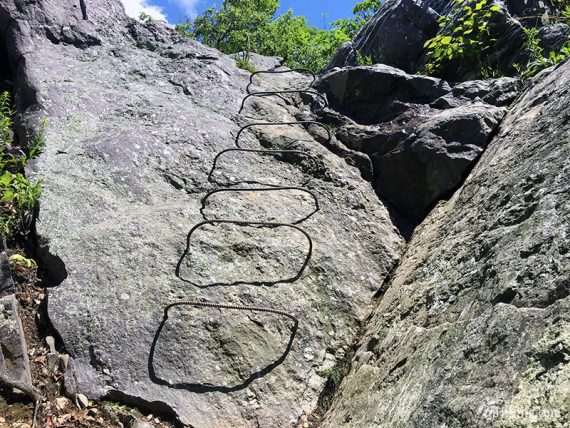 Metal rung ladder on a rock face.