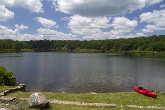 Crater Lake with a red kayak at waters edge.