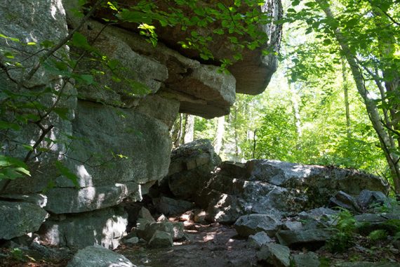 Rock overhanging a trail.