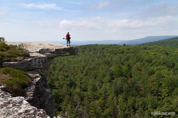 Hiker on an overhanging cliff edge.