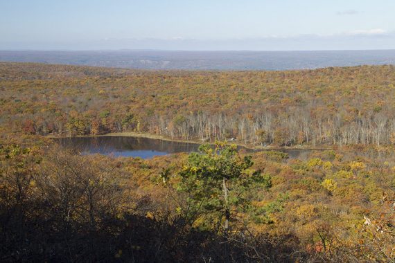 Sawmill Lake in the distance surrounded by fall foliage.