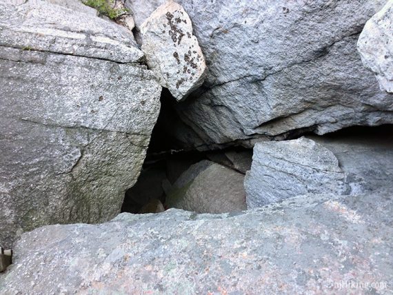 A narrow passage inbetween a jumble of rocks.