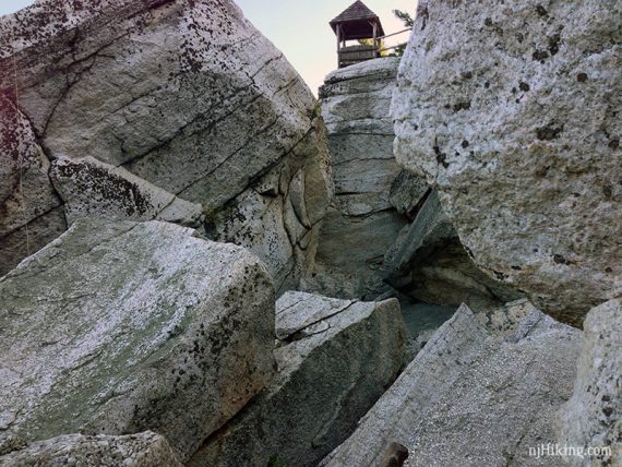 Looking up a labyrinth of rocks to a tower at the top.