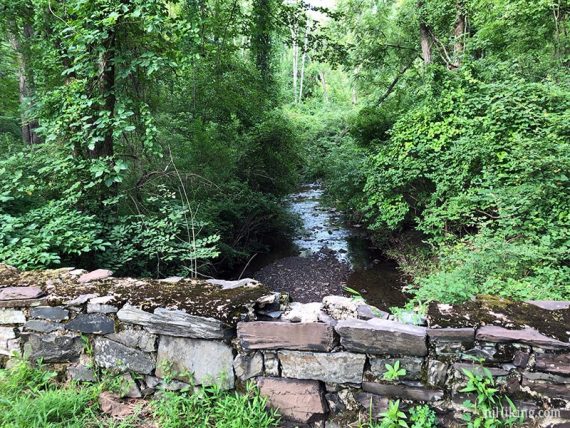 Stone retaining wall next to a stream