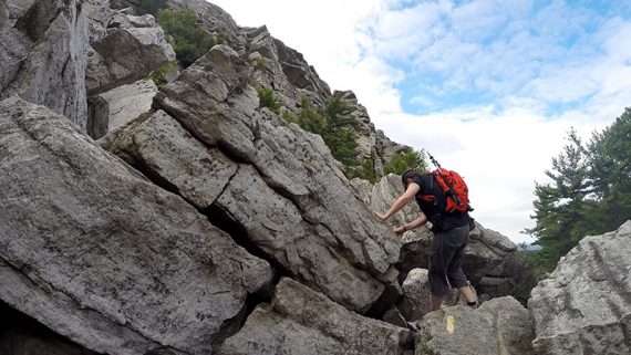 Hiker negotiating large rocks.
