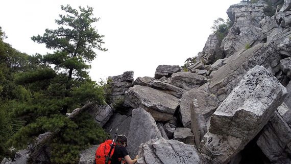 Hiker approaching a large jumble of rocks.