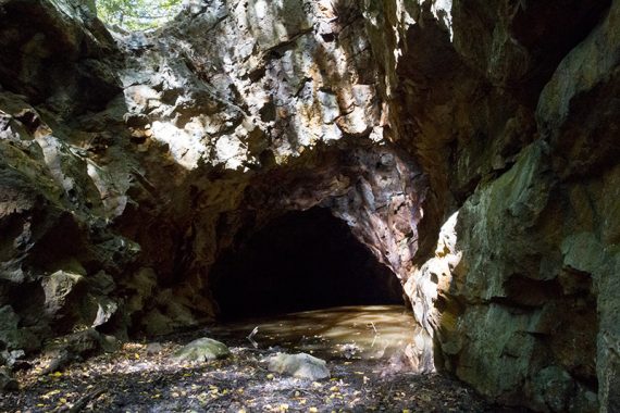 Boston Mine entrances carved into the rock and partially filled with water.