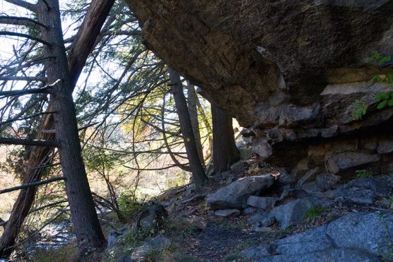 Large rock overhanging a trail