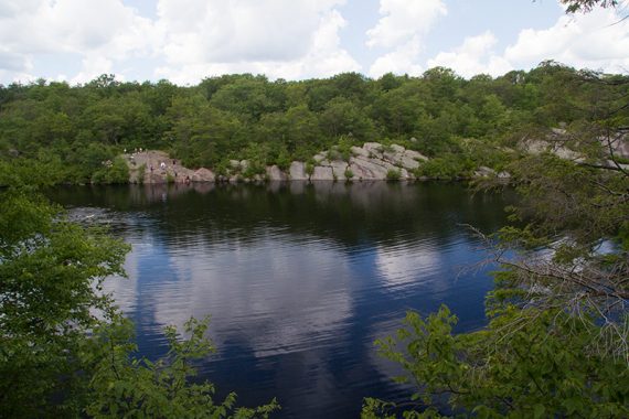 Pond with people sitting on the rocky sides.
