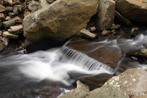 Water cascading over an angled rock.