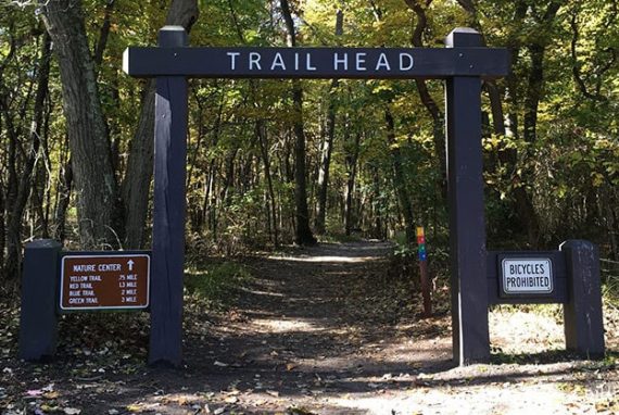 Wooden arch with the word Trailhead painted on it.