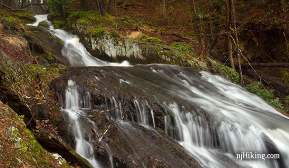 Water cascading over rocks with moss on the sides