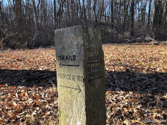 Stone marker at a trail intersection.