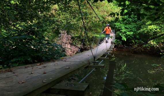 Hiker crossing the swinging bridge in Princeton New Jersey.