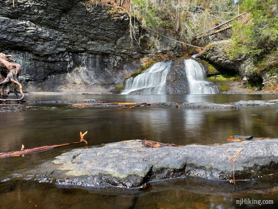 Hackers Falls cascading into a large pool of water with a rock in the foreground.