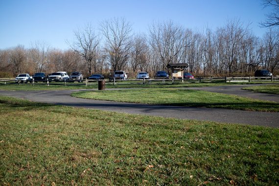 Marlu Lake parking lot with a paved path and grass in front of it.