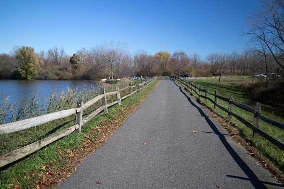 Paved path with a split-rail fence on either side.