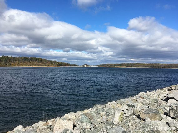 Bright blue water with a stone dam edge