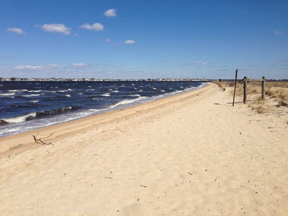 Wide sandy beach with small waves breaking into white caps.