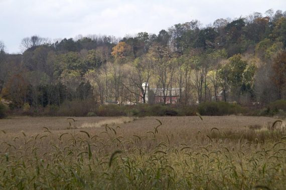 Pass a field and barn/silo in the distance