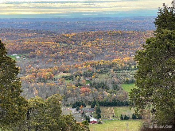 Zoom into a red farmhouse and fall foliage in the valley below.