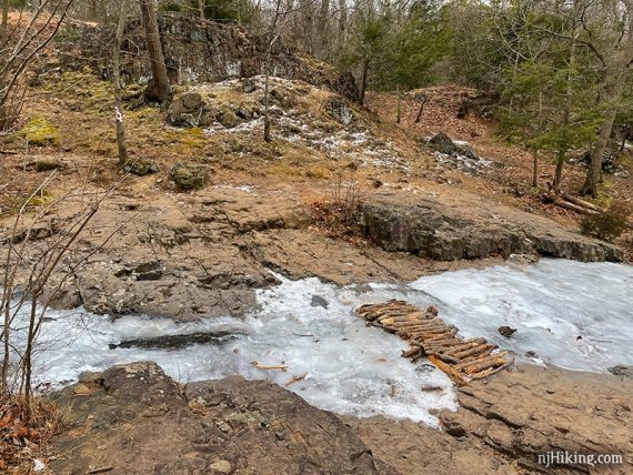 Logs placed over a frozen brook.