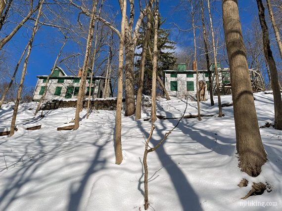 Village buildings at the top of a snowy hill.