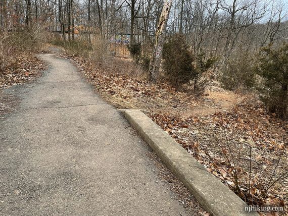 Dirt path branching off from a paved trail.