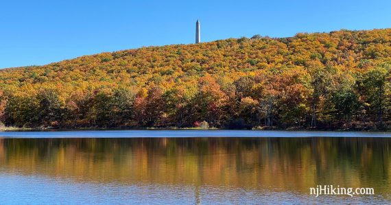 High Point Monument surrounded by fall foliage reflected in Steeny Kill Lake.