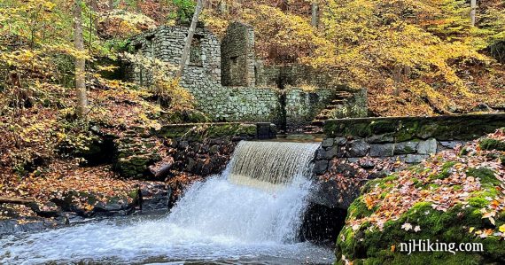 Ruins of Kay's Cottage and water cascading over a dam.