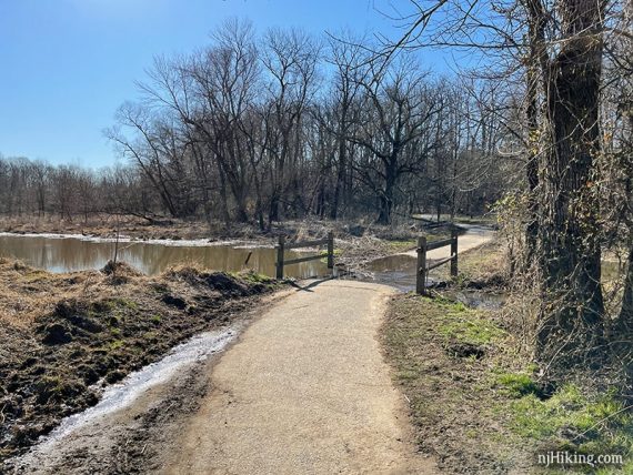 Paved path and fence at a pond