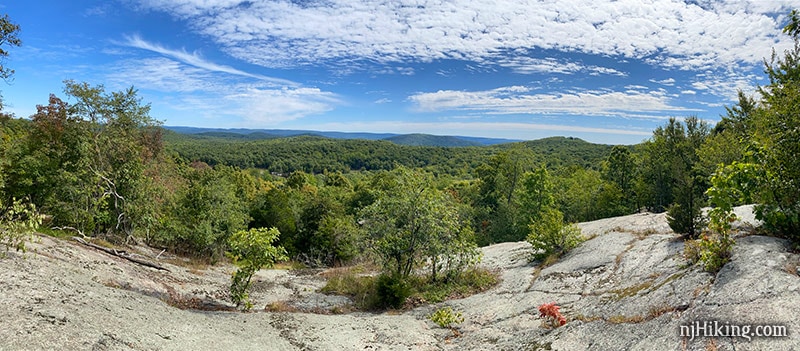 Panorama of green foliage covered mountains with rocky outcrop