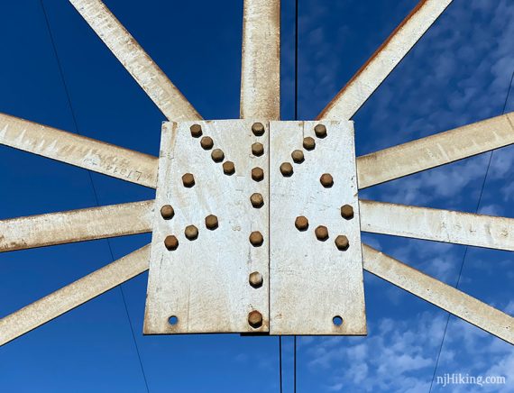 Close up of metal bars, plate, and rivets on a power line tower