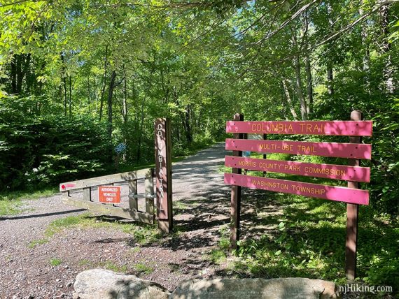 Columbia Trail red sign next to a post and gate.