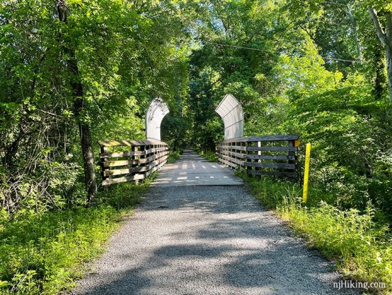 Gravel rail trail bridge with fenced sides.