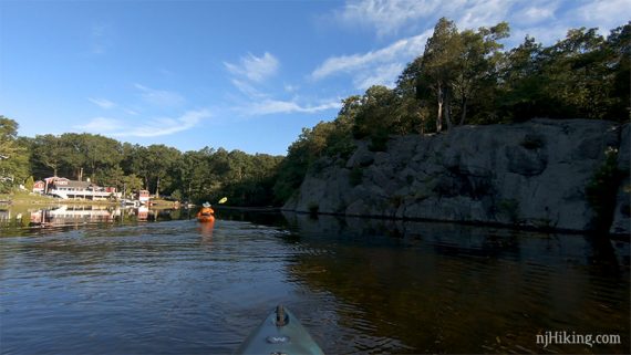 Kayaker near a large cliff face on a lake